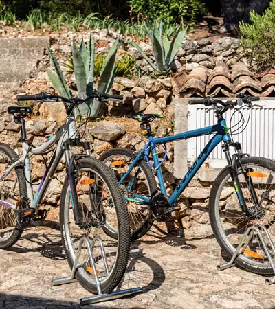 Bicycles in front of a stone wall with agave plants at House Agave, Vis