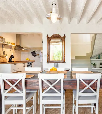 Open kitchen and dining area under a whitewashed beamed ceiling