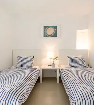 Twin bedroom with two single beds and a framed print of the sea